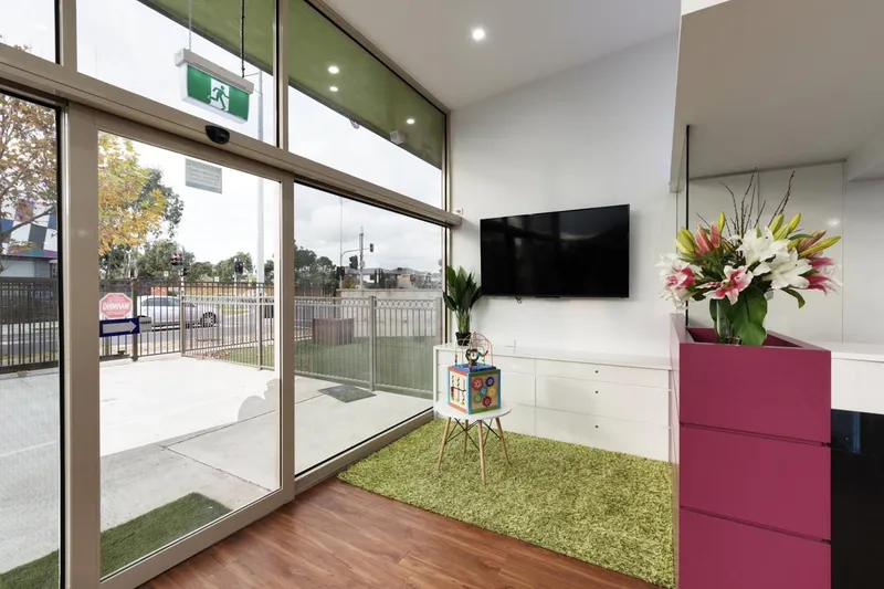 The Caroline Springs clinic's kids area — bright window, soft green rug, a small toy cube on a stool. Calm and unhurried.