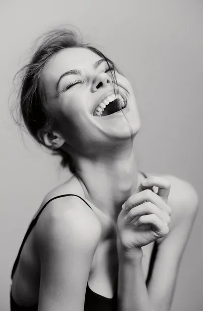 A woman laughing freely with her head tilted back