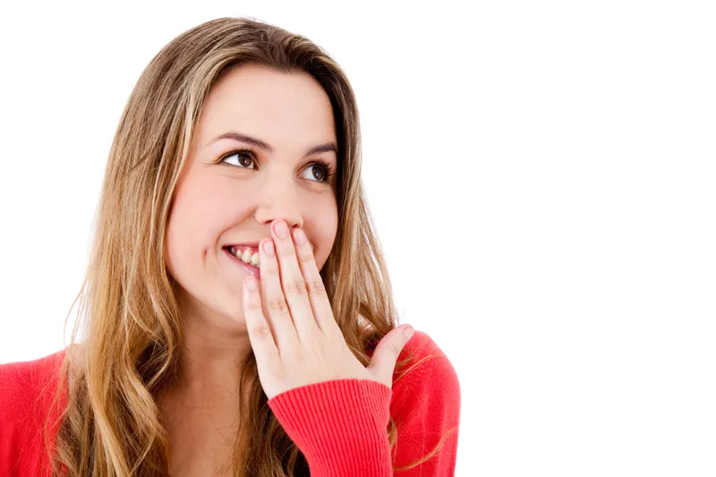 A woman laughing with her hand near her mouth