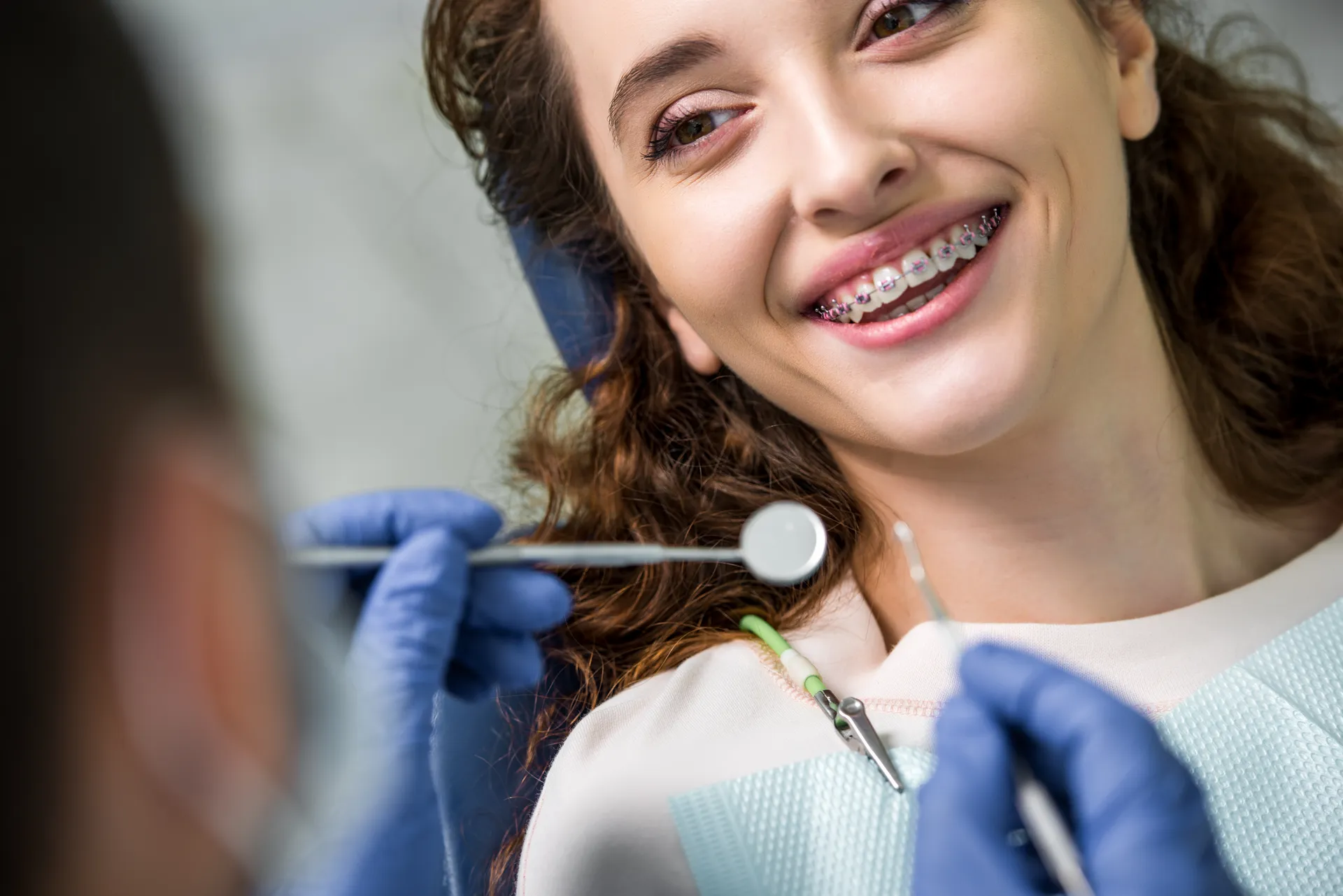 An existing patient smiling comfortably during a routine check-in, at ease asking about her smile
