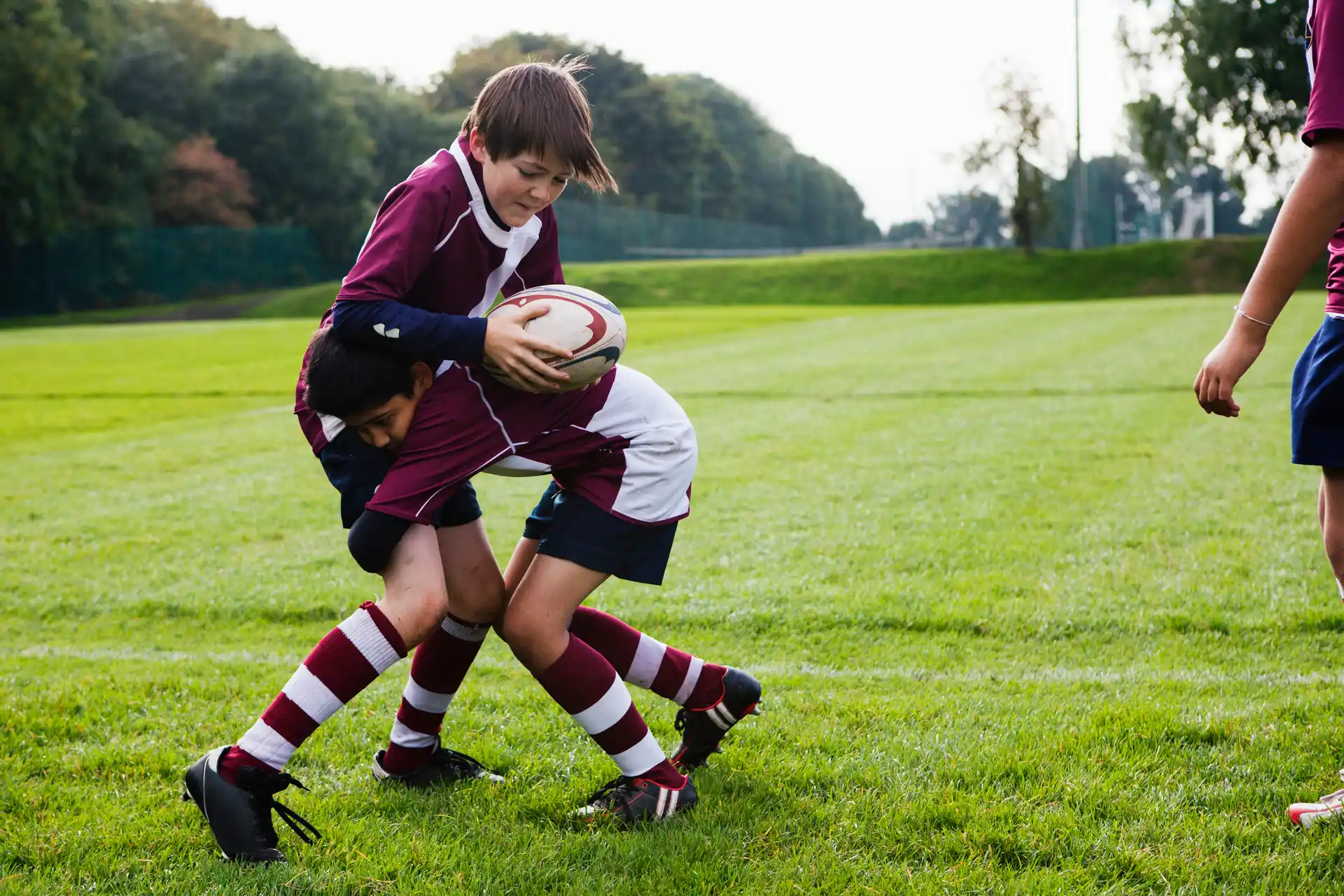 Young boys playing rugby on a grass field