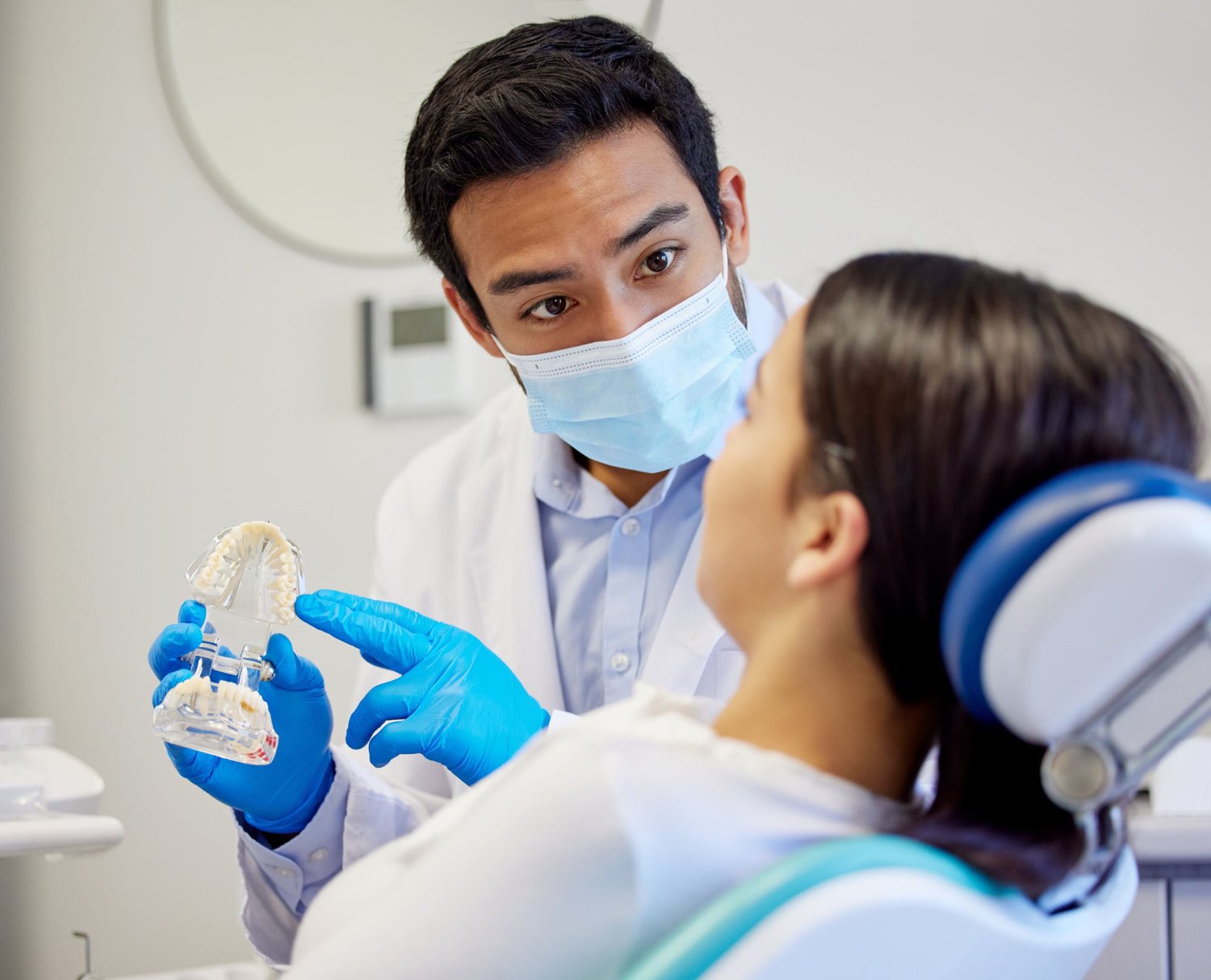 A dentist calmly explaining a procedure to a patient before treatment
