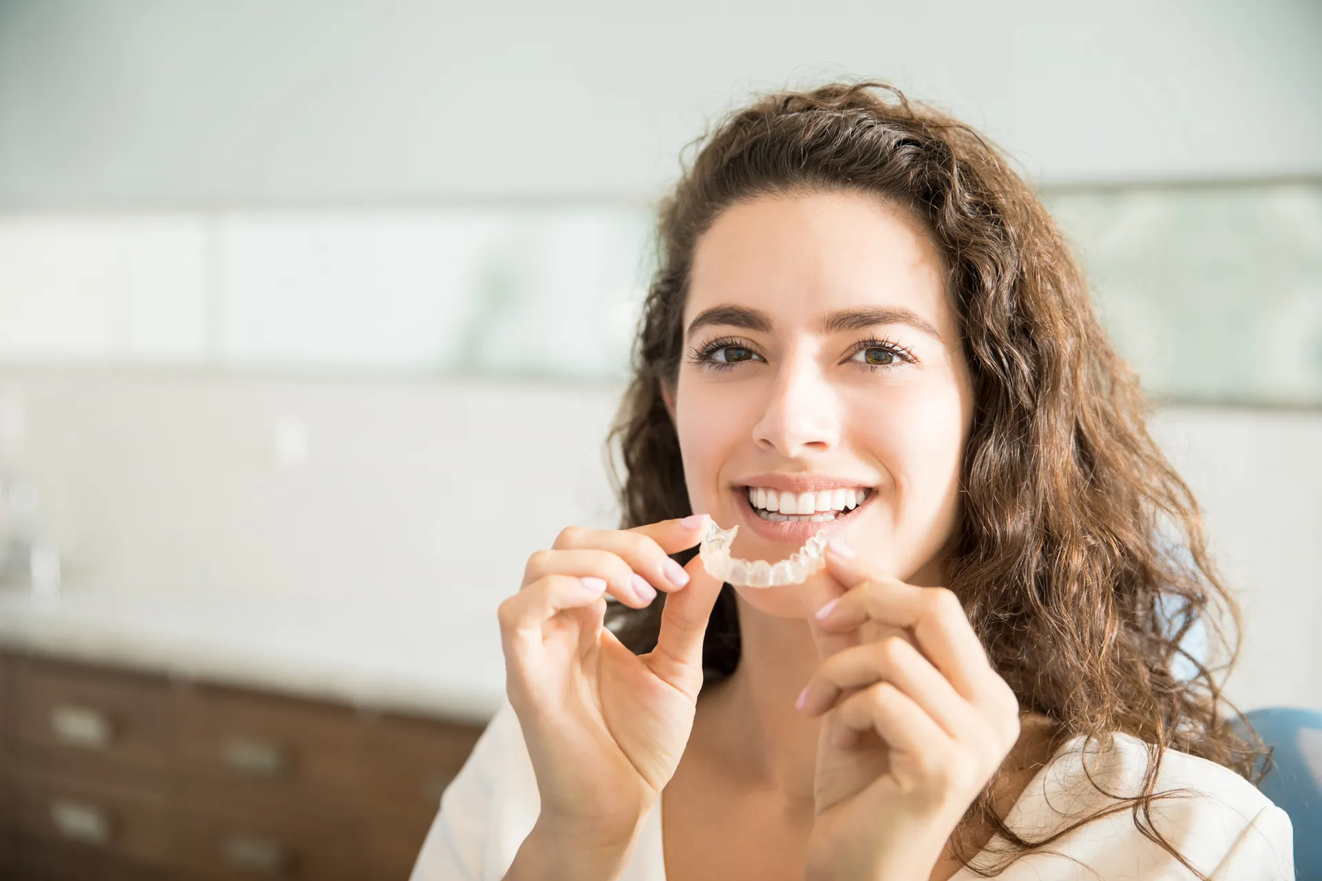Patient holding clear orthodontic aligners