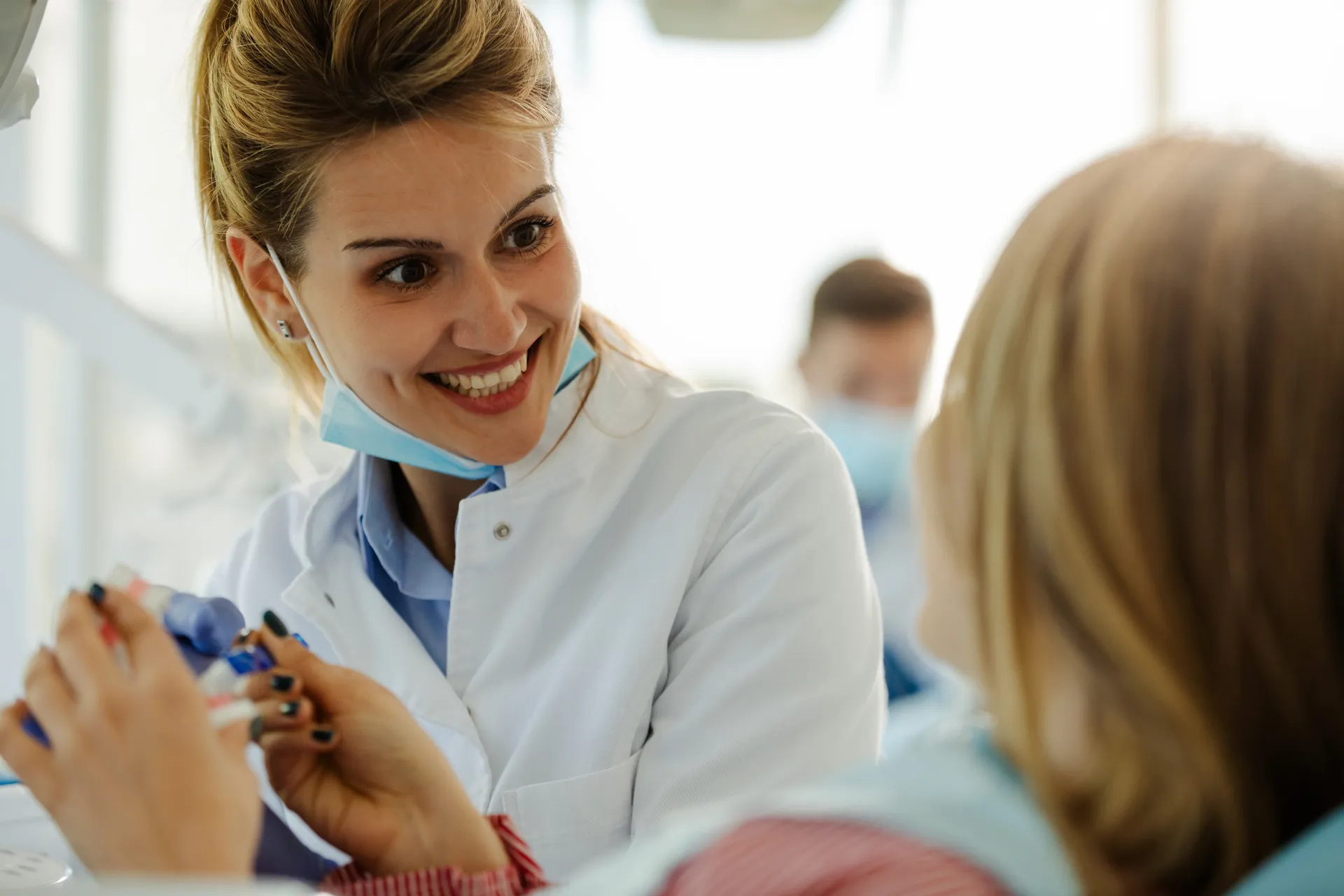 A dentist warmly explaining a treatment plan to an existing patient during a routine visit
