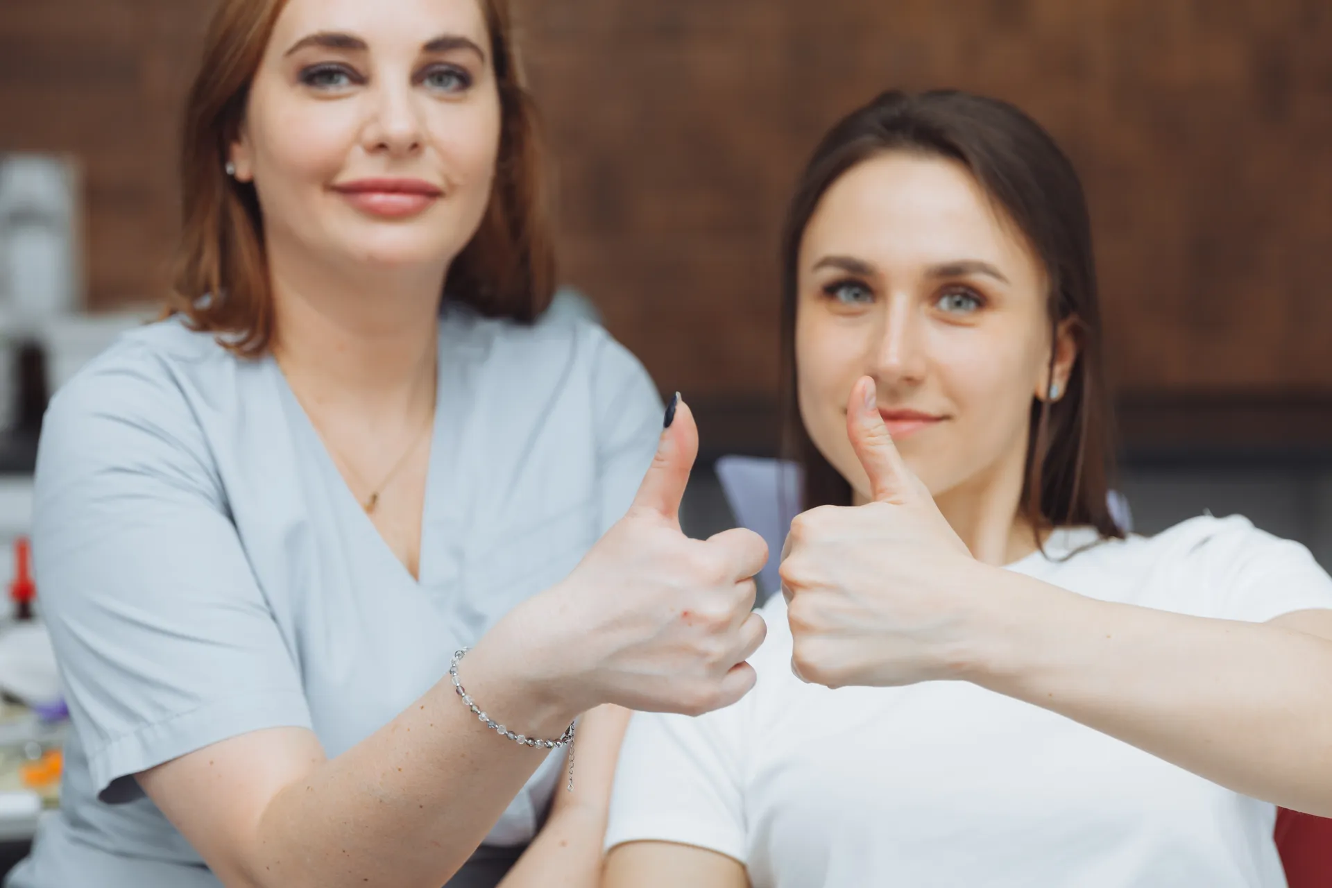 Two smiling women giving a thumbs up